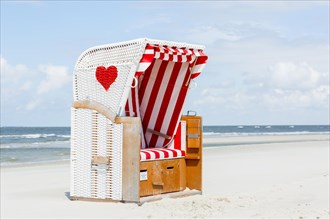 Beach chair with red heart on the beach