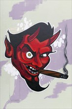 Red devil smoking cigar