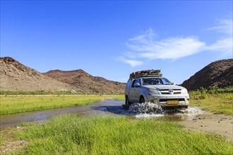 Off-road vehicle crosses Hoarusib River