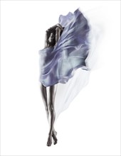 Beautiful woman with flowing blue translucent cloth wrapping her nude body and fluttering like wings