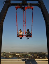 Children sway in the Swing 'Over The Edge high above the rooftops of Amsterdam on the A'DAM LOOKOUT