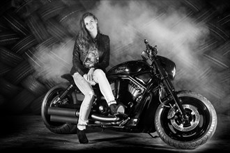 Woman in a leather jacket sitting on a motorcycle