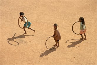 Children playing with tires on village street