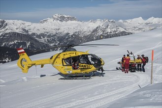 Injured skier is transported by snowmobile in rescue helicopter OAMTC