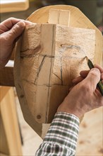 Drawing the outline of a face on a wooden block