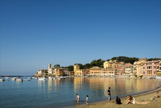 People on the beach in the bay Baia del Silenzio