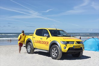 Yellow car with inscription Livredder on Henne Beach