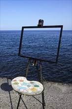 Easel and pallet in front of the sea