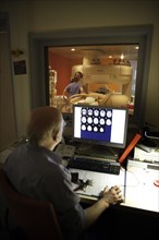 Doctor monitoring computer radiographs of MRI machine