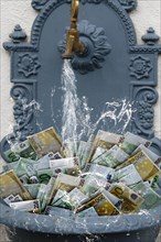 Counterfeit money in fountain with water running