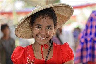 Local woman with straw hat and Thanaka paste on her face