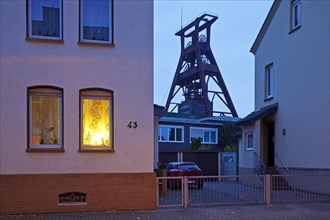 Residential buildings with the winding tower of Pluto colliery at dusk
