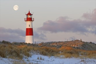 Red and white striped lighthouse List East in the dunes at the full moon