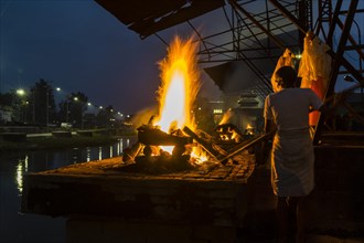 Cremation of a dead body at the burning ghats at night