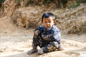 Little boy sitting on the ground