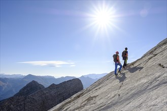 Mountain guide guiding a young woman on a short rope through a rock face