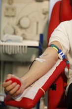 Patient with an infusion needle taking a blood sample at the transfusion ward of a hospital