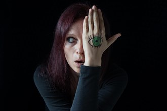 Woman with painted eye on her hands