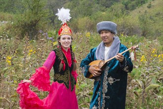 Kazakh man singing and playing the dombra for a woman