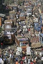 Merchants between trucks loaded with bags