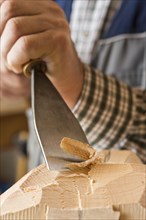 Carving a wooden block using wood carving tools