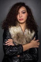 Young woman with curly hair in black jacket