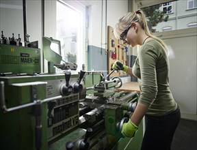 Young woman working on lathe