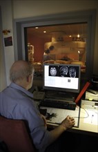 Doctor monitoring computer radiographs of MRI machine