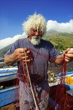 Fishermen repair nets at Scari Beach