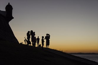 Adults and children at sunset