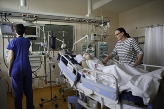 Child in hospital bed with mother in the ICU