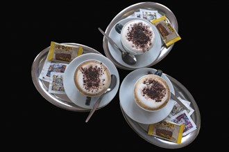 Three cappuccino on silver trays