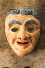 Painted wooden mask on a workbench
