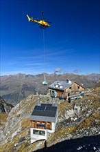Helicopter Eurocopter AS350 Ecureuil on a supply flight from the Swiss Alpine Club to Lischana Hut