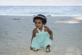 Little Maldivian girl on the sandy beach