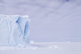 Iceberg seen from frozen fjord