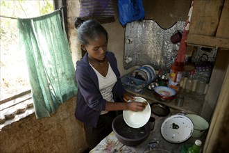 Young woman washes dishes