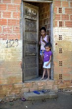 Two children stand in a door entrance