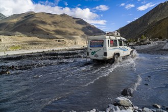 Jeep taxi is crossing a river