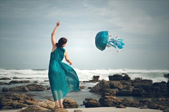 Woman flying a jellyfish kite at the beach