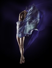 Beautiful woman with flowing blue translucent cloth wrapping her nude body and fluttering like wings