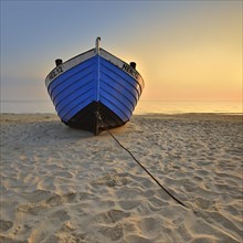 Fishing boat on beach at sunrise