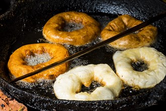 Doughnuts are fried in a pan with hot oil