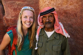 Tourist girl poses with old man