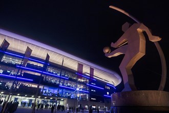 Sculpture of a soccer player in front of Wirsol Rhein-Neckar-Arena illuminated at night