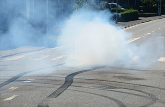 Car burning tire on a street