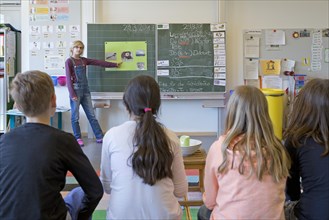 Schoolgirl at the blackboard giving a presentation to fellow students