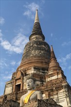 Buddha statue in front of large Chedi