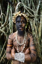 Tribal warrior in front of the roots of the banyan tree