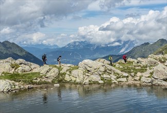 Hikers on trail by mountain lake